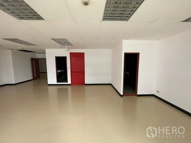 Office Space for rent in Pathum Wan, Bangkok - Main office area with multiple doorways, a red fire door and smooth beige flooring.
