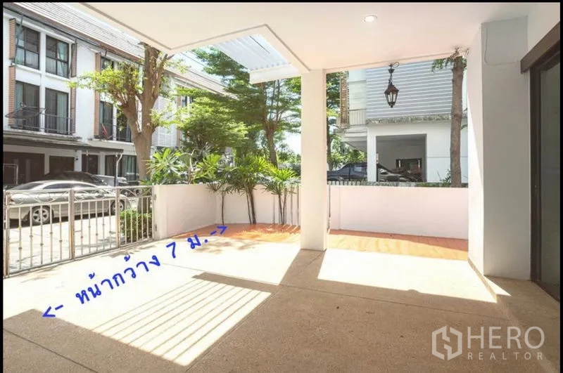 Townhouse for sale in Khlong Toei, Bangkok - Covered front terrace and wide frontage carport facing a quiet townhouse community.