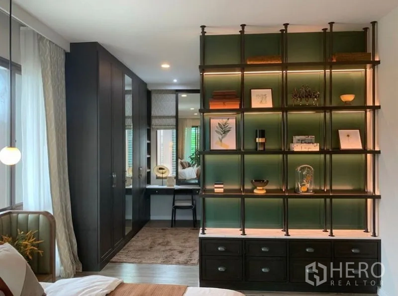 Detached House for sale in Bang Kapi, Bangkok - Secondary bedroom featuring illuminated shelving, wardrobes and a dressing area.