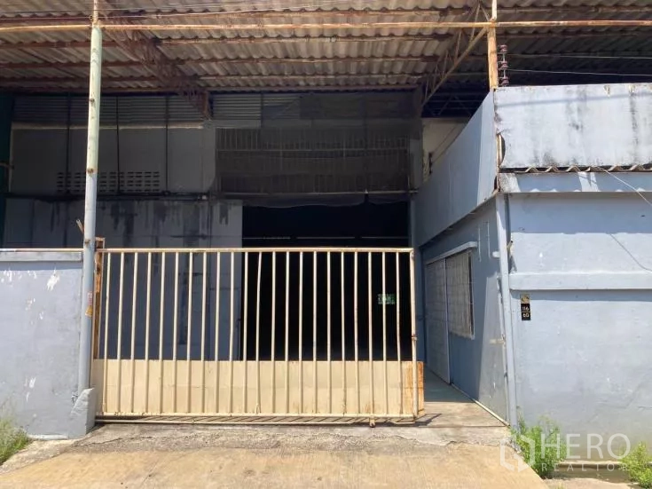 Factory for rent in Bang Sao Thong, Samut Prakan - Factory front with sliding metal gate and covered loading bay in Bang Sao Thong.