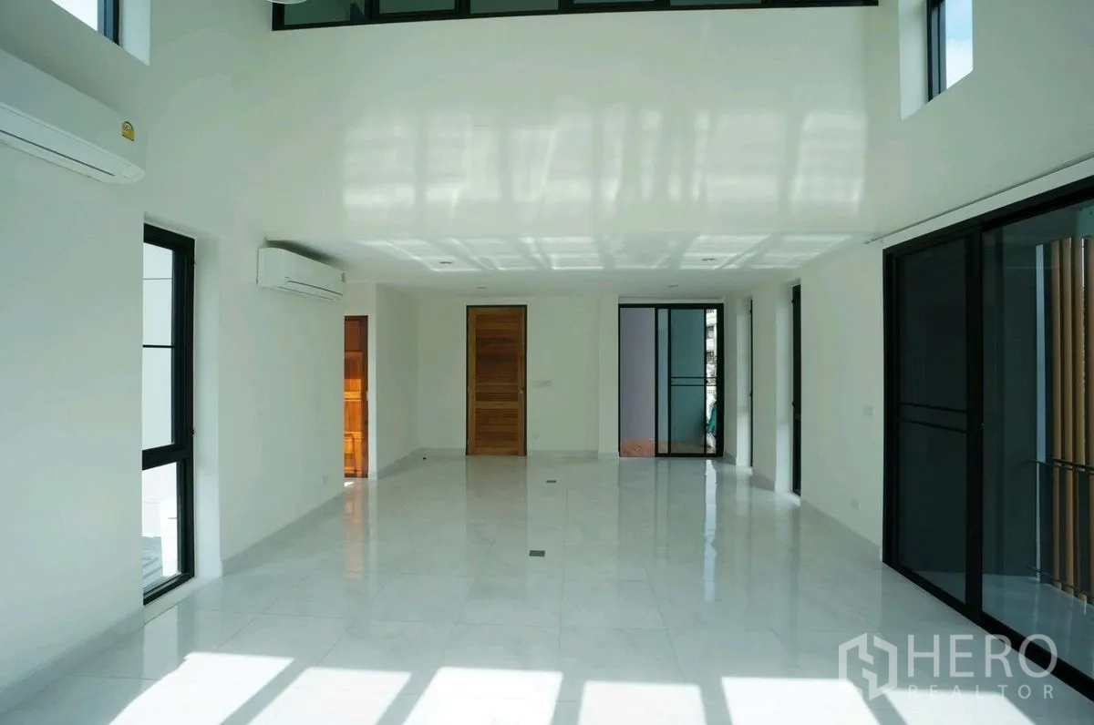 Home Office for rent in Chatuchak, Bangkok - Spacious white-tiled hall with multiple windows and air conditioners.