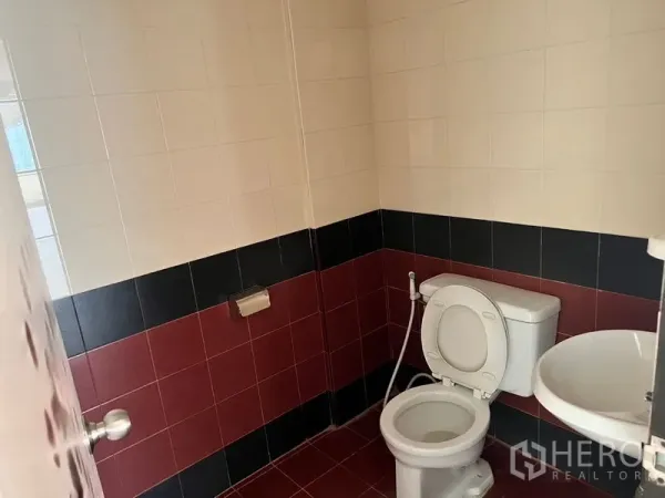 Office Space for rent in Pathum Wan, Bangkok - Small office restroom with white basin and toilet, finished with red and black wall tiles.