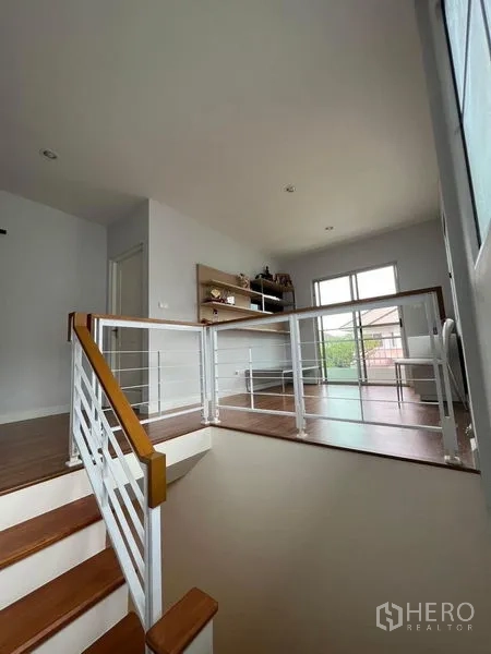 Detached House for sale in Bang Kruai, Nonthaburi - Stair landing with modern railing, shelves and plenty of natural light.