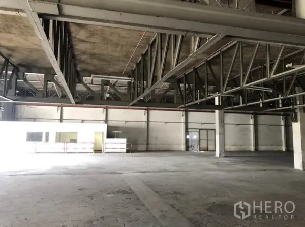Warehouse for rent in Lam Luk Ka, Pathum Thani - Close-up of steel mezzanine structure and open work area inside the warehouse.