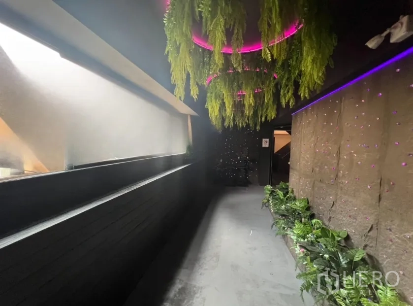 Retail Space for rent in Watthana, Bangkok - Corridor with hanging greenery and pink LED accents leading deeper into the venue.