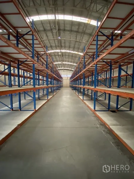 Warehouse for rent in Bang Phli, Samut Prakan - High-bay warehouse interior with long rows of pallet racking under an arched roof.