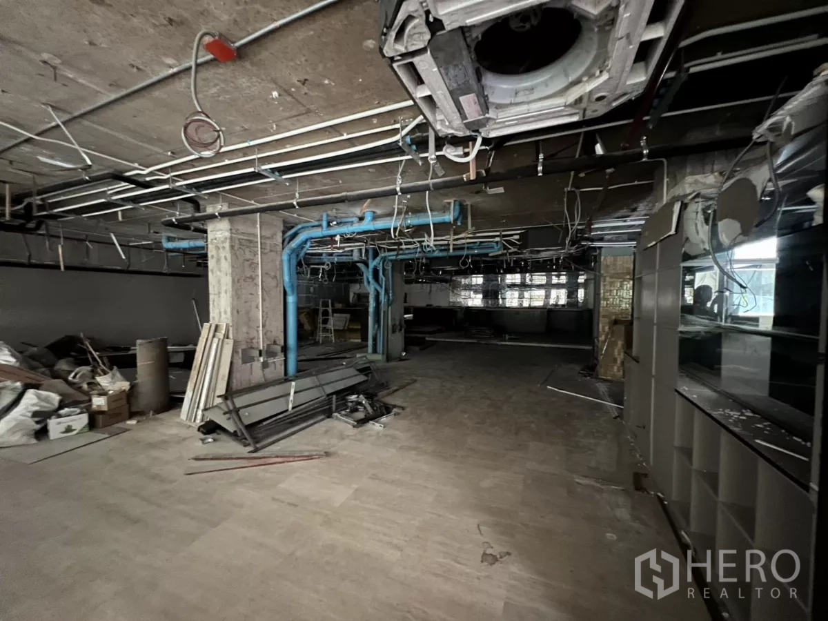 Retail Space for rent in Khlong Toei, Bangkok - Raw interior with exposed ceiling ducts, blue plumbing and an open floor plate.