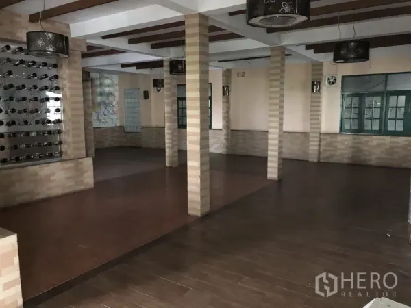 Retail Space for rent in Khlong Toei, Bangkok - Open-plan hall with multiple columns, wood-look flooring, feature lighting and large windows.