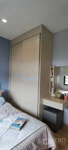 Townhouse for rent in Prawet, Bangkok - Bedroom corner with built‑in sliding wardrobe and vanity in neutral tones.
