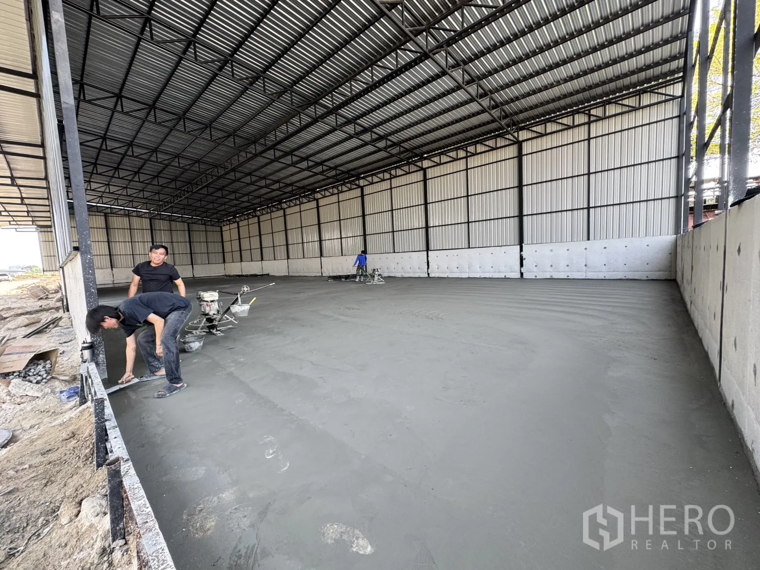 Warehouse for rent in Lam Luk Ka, Pathum Thani - Interior of a warehouse showing a new heavy‑duty concrete floor and steel truss roof.