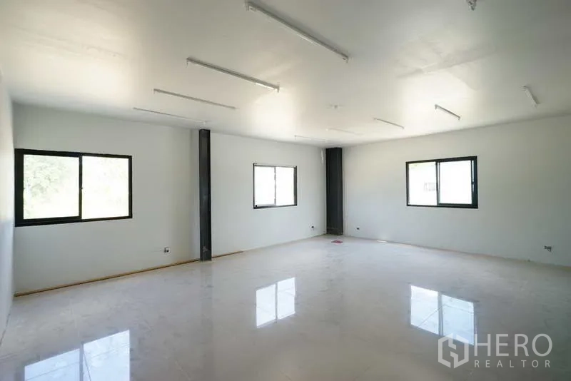 Factory for rent in Chon Buri - Bright second-floor office room with windows and linear LED lighting.
