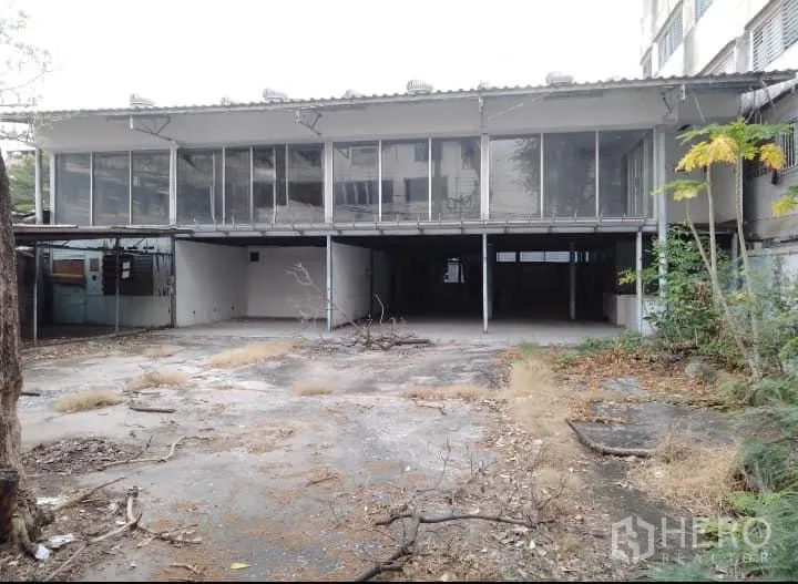 Warehouse for rent or sale in Bang Kho Laem, Bangkok - Open forecourt leading to an elevated warehouse structure with shaded parking and loading area.