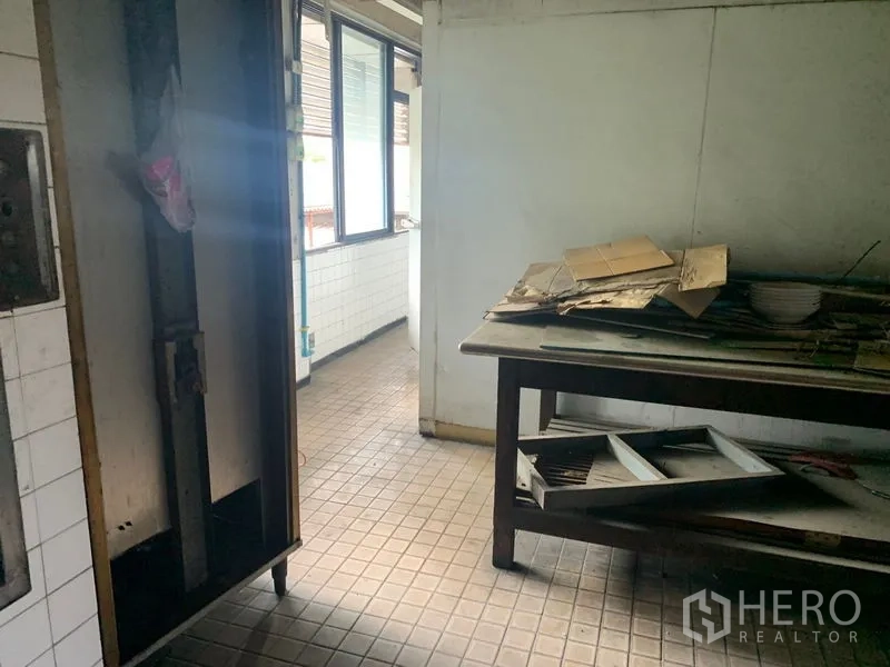 Shophouse for rent in Watthana, Bangkok - Kitchen workspace with small tiles, stainless table and openable windows.