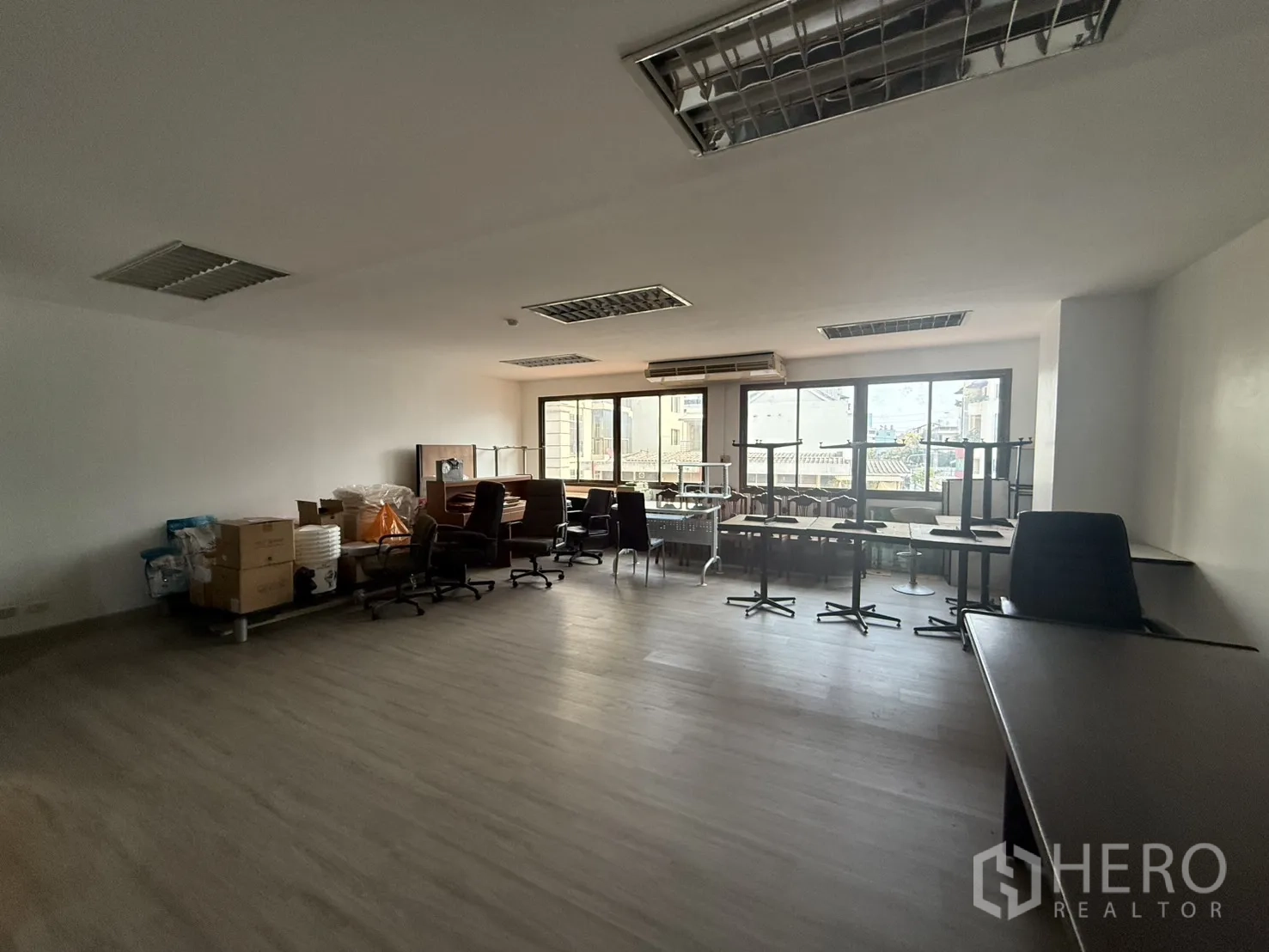 Office Space for rent in Sathon, Bangkok - Unfurnished office room with white walls, laminate floor, grid ceiling lights, and panoramic windows providing natural light.