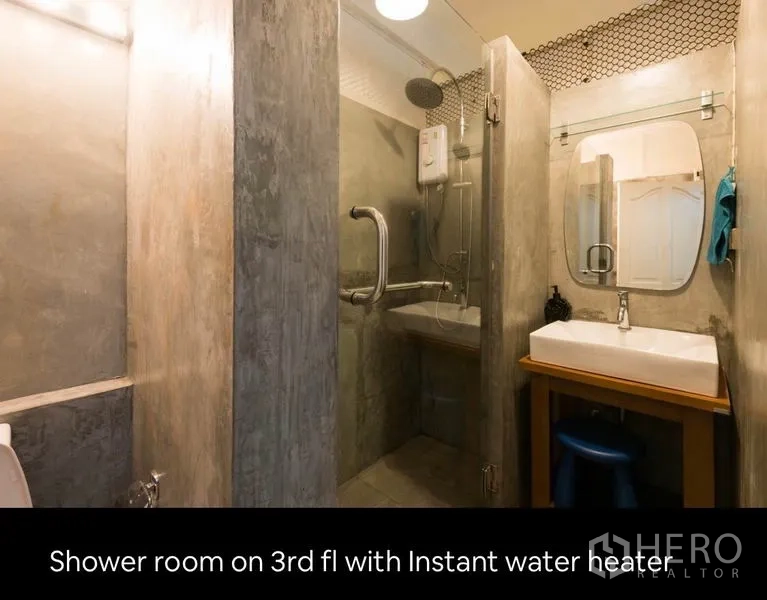 Townhouse for rent in Khlong Toei, Bangkok - Third-floor bathroom with glass shower enclosure, instant water heater and vanity sink.