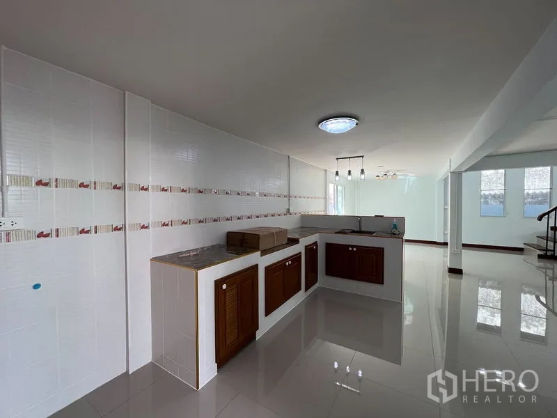独立式住宅 出租在Khlong Toei, Bangkok - L 型厨房，墙面瓷砖、木质柜体，开放式布局。