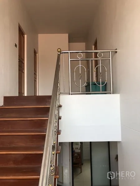 Detached House for sale in Lam Luk Ka, Pathum Thani - Wooden staircase with metal balustrade.
