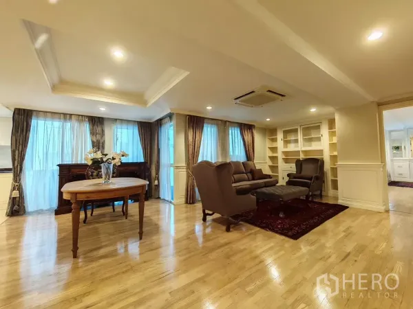 Condominium for rent in Pathum Wan, Bangkok - Bright living and dining area with full-height curtains, built-in shelves and recessed lighting.