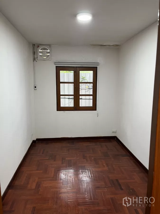 独立式住宅 出租在Watthana, Bangkok - 小卧室，木地板、白墙与木框窗户。