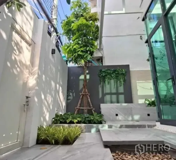 Home Office for rent in Suan Luang, Bangkok - Landscaped courtyard with small tree, planter boxes, stone path and glass doors.