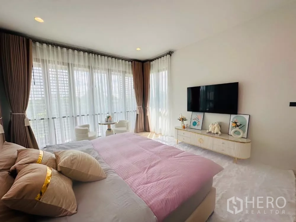 Detached House for rent or sale in Bang Kapi, Bangkok - Master bedroom media wall with mounted TV and long low cabinet.