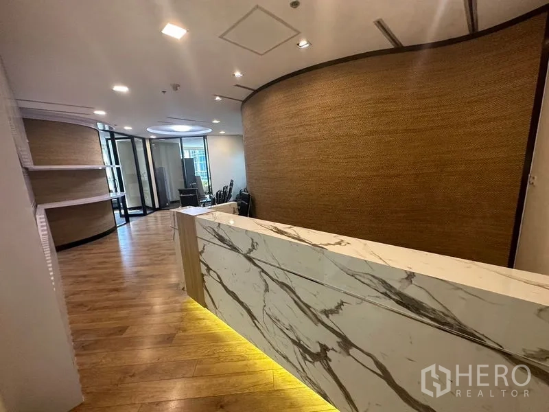 Office Space for rent - Modern reception featuring a marble-front counter, warm wood flooring and a curved feature wall.
