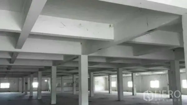 Factory for rent or sale in Khlong Toei, Bangkok - Wide industrial hall with grid ceiling beams and multiple windows for natural light.