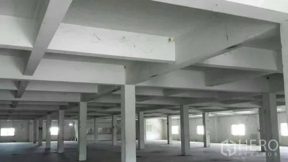 Factory for rent or sale in Khlong Toei, Bangkok - Wide industrial hall with grid ceiling beams and multiple windows for natural light.