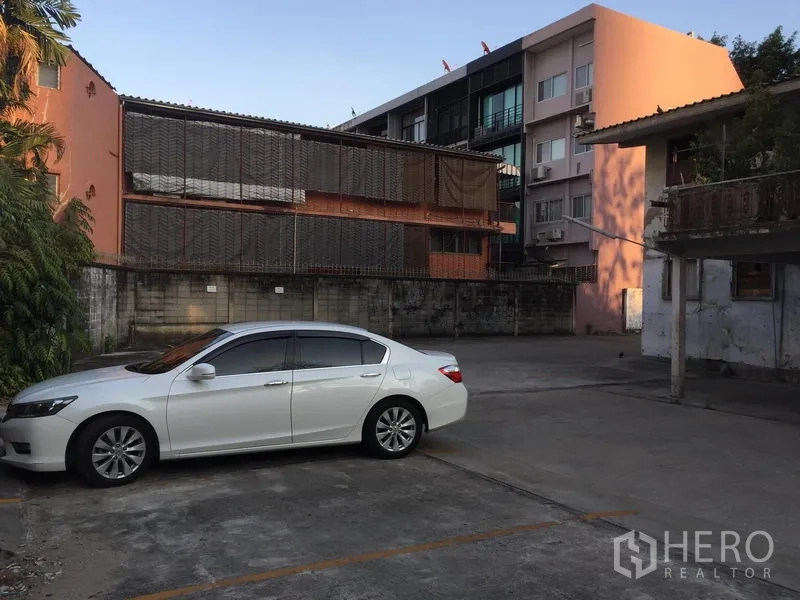 Retail Space for rent in Khlong Toei, Bangkok - Open parking lot beside low-rise buildings, showing ample on-site customer parking space.