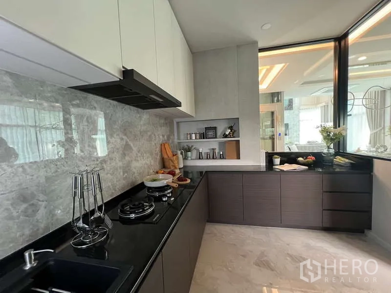 独立式住宅 出售在Suan Luang, Bangkok - 独立泰式厨房，L型台面与石纹墙面