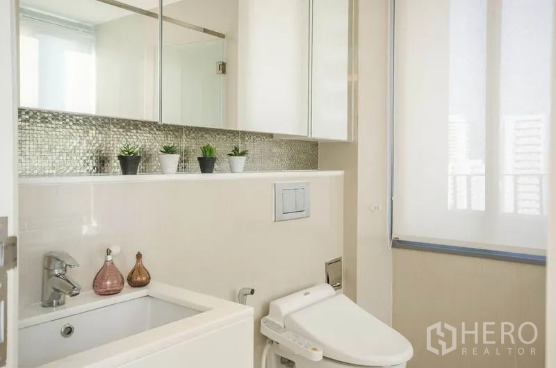 Condominium for rent or sale in Watthana, Bangkok - Second bathroom with vanity, bidet toilet and mosaic backsplash.