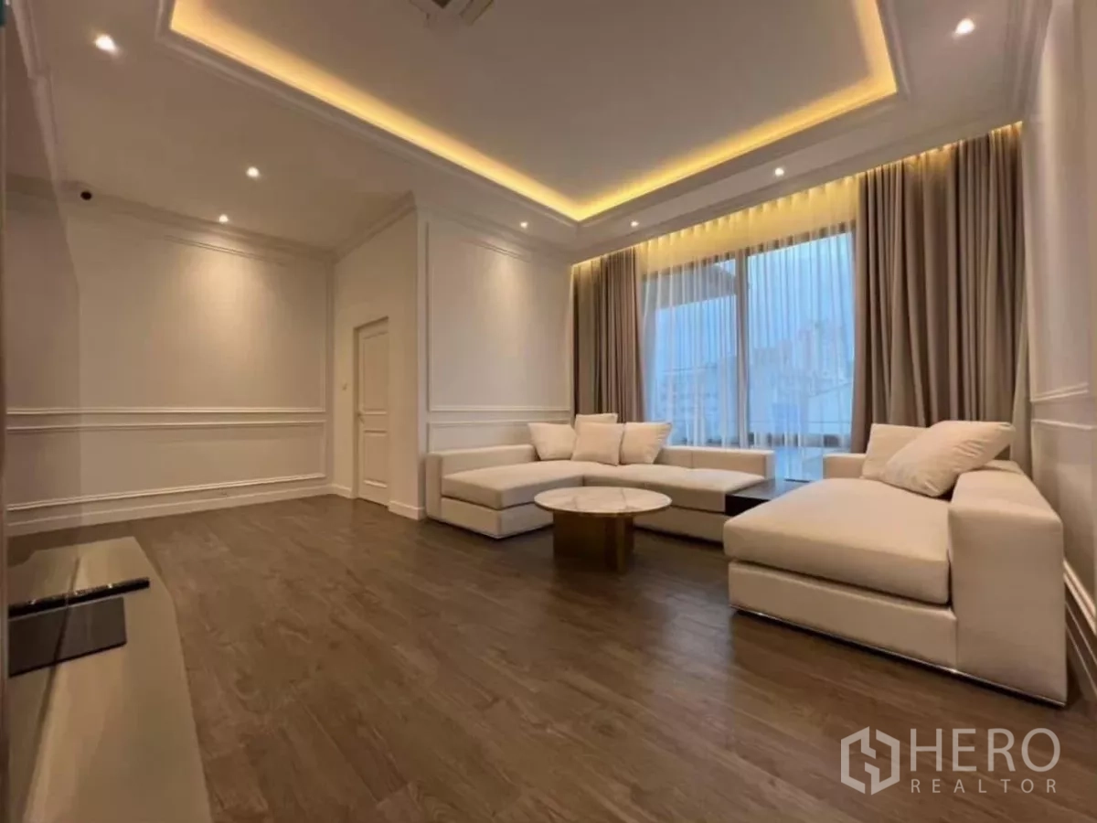 Detached House for rent in Phaya Thai, Bangkok - Spacious family room with cove lighting, wood floors and large windows with sheer curtains.