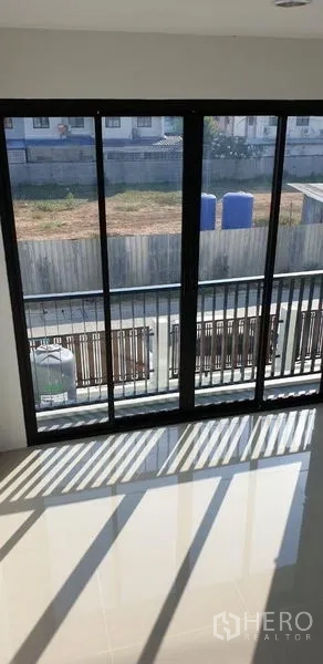 工厂 出租在Lam Luk Ka, Pathum Thani - 通往阳台的推拉落地窗，可见前方围栏