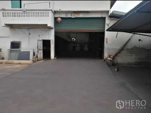 Warehouse for rent in Prawet, Bangkok - Close view of main roller shutter entrance and driveway for loading.