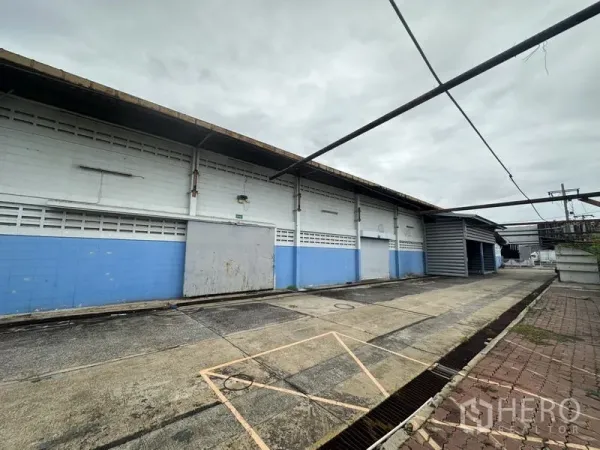 工厂 出售在Khlong Luang, Pathum Thani - 仓库外墙一侧，设装卸门与带顶棚的服务通道。