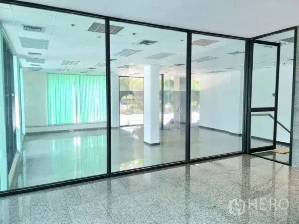 Retail Space for rent in Sathon, Bangkok - View through an interior glass partition into a roomy retail area with polished flooring and wide windows.
