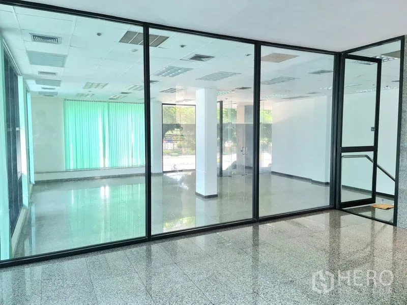 Retail Space for rent in Sathon, Bangkok - View through an interior glass partition into a roomy retail area with polished flooring and wide windows.