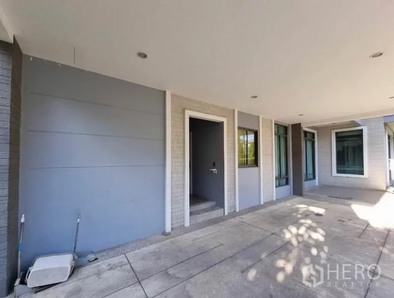 Detached House for sale in Suan Luang, Bangkok - Covered carport and entry porch with recessed lighting and large windows.