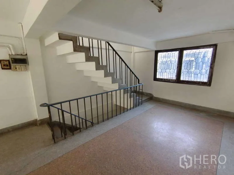 Shophouse for rent in Bang Na, Bangkok - Landing area with stairwell and window, suitable for an office corner.