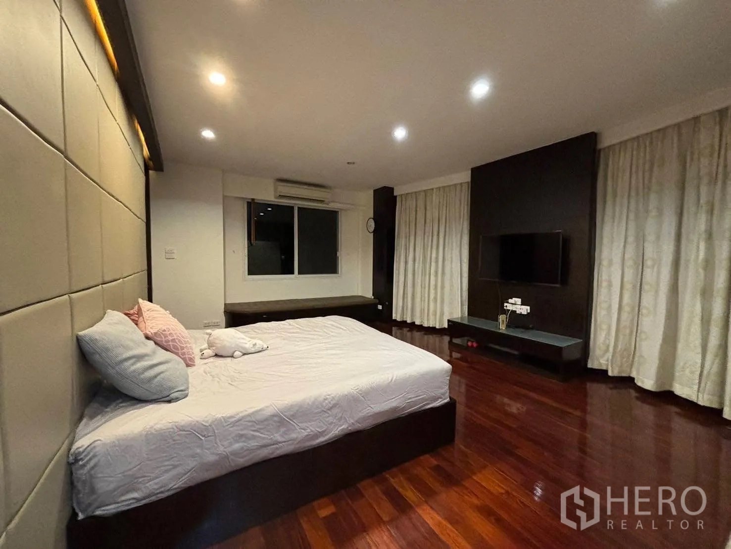 Detached House for rent in Bang Kapi, Bangkok - Master suite with TV wall, curtains and polished wood floor.