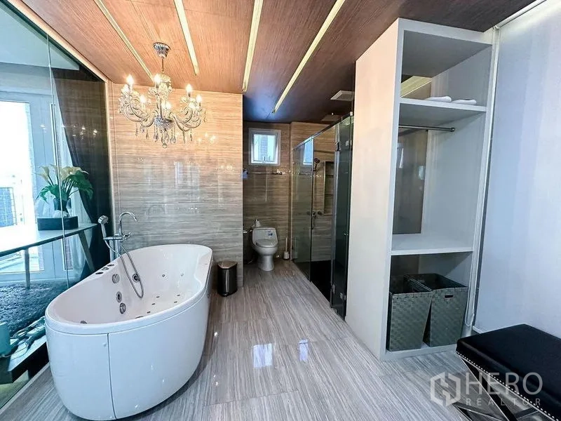 Condominium for rent or sale in Khlong Toei, Bangkok - Luxury bathroom with freestanding soaking tub, glass shower and chandelier.