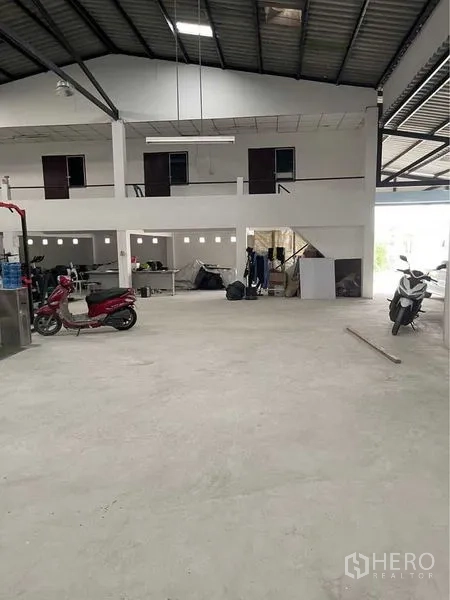 Warehouse for sale in Lam Luk Ka, Pathum Thani - Spacious warehouse interior with high ceiling, mezzanine offices and smooth concrete floor in Lam Luk Ka.