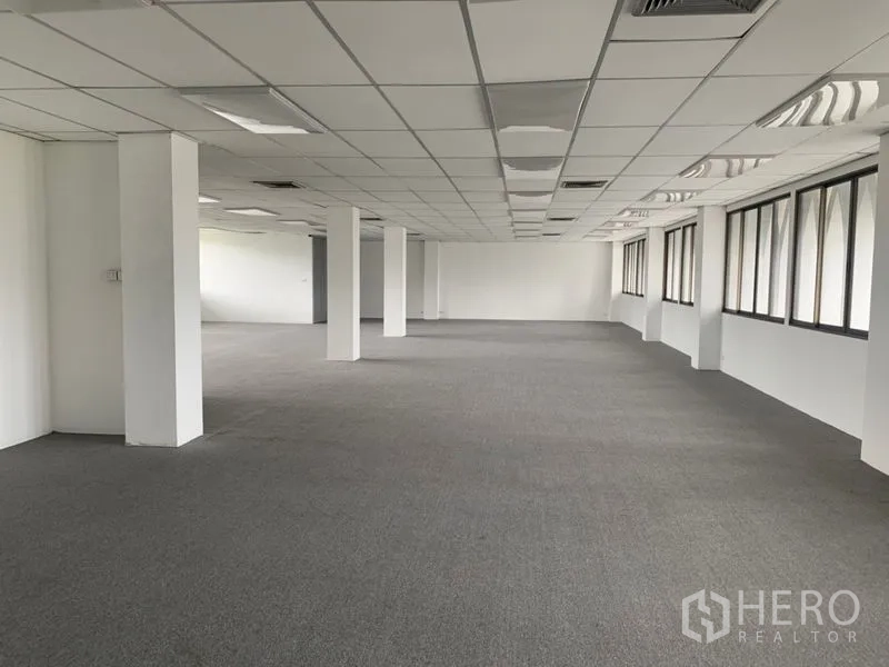 办公空间 出租在Ratchathewi, Bangkok - 长方形办公空间，多根立柱，铺设地毯，成排窗户采光充足。