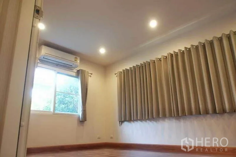 Detached House for rent or sale in Pak Kret, Nonthaburi - Bright room with air conditioning, recessed lights, long curtains and wood-style flooring.