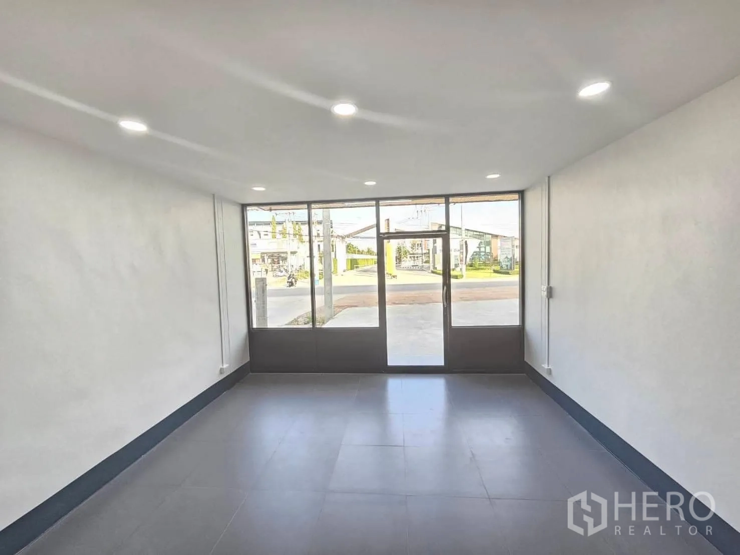 Warehouse for rent in Lam Luk Ka, Pathum Thani - Bright office room with LED downlights and a full-height glass entrance.