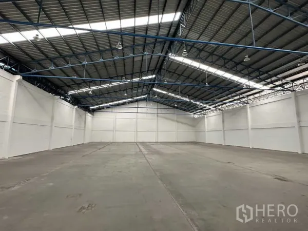 Factory for rent in Bang Phli, Samut Prakan - Clear-span warehouse interior highlighting unobstructed floor space and bright roof lighting.