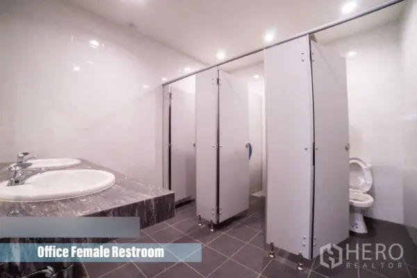 Home Office for rent in Khlong Toei, Bangkok - Clean restroom featuring multiple toilet stalls and double sinks on a stone countertop.