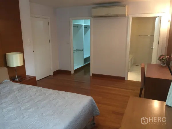独立式住宅 出租在Watthana, Bangkok - 主卧配实木地板、空调、步入式衣帽间与套内卫生间。