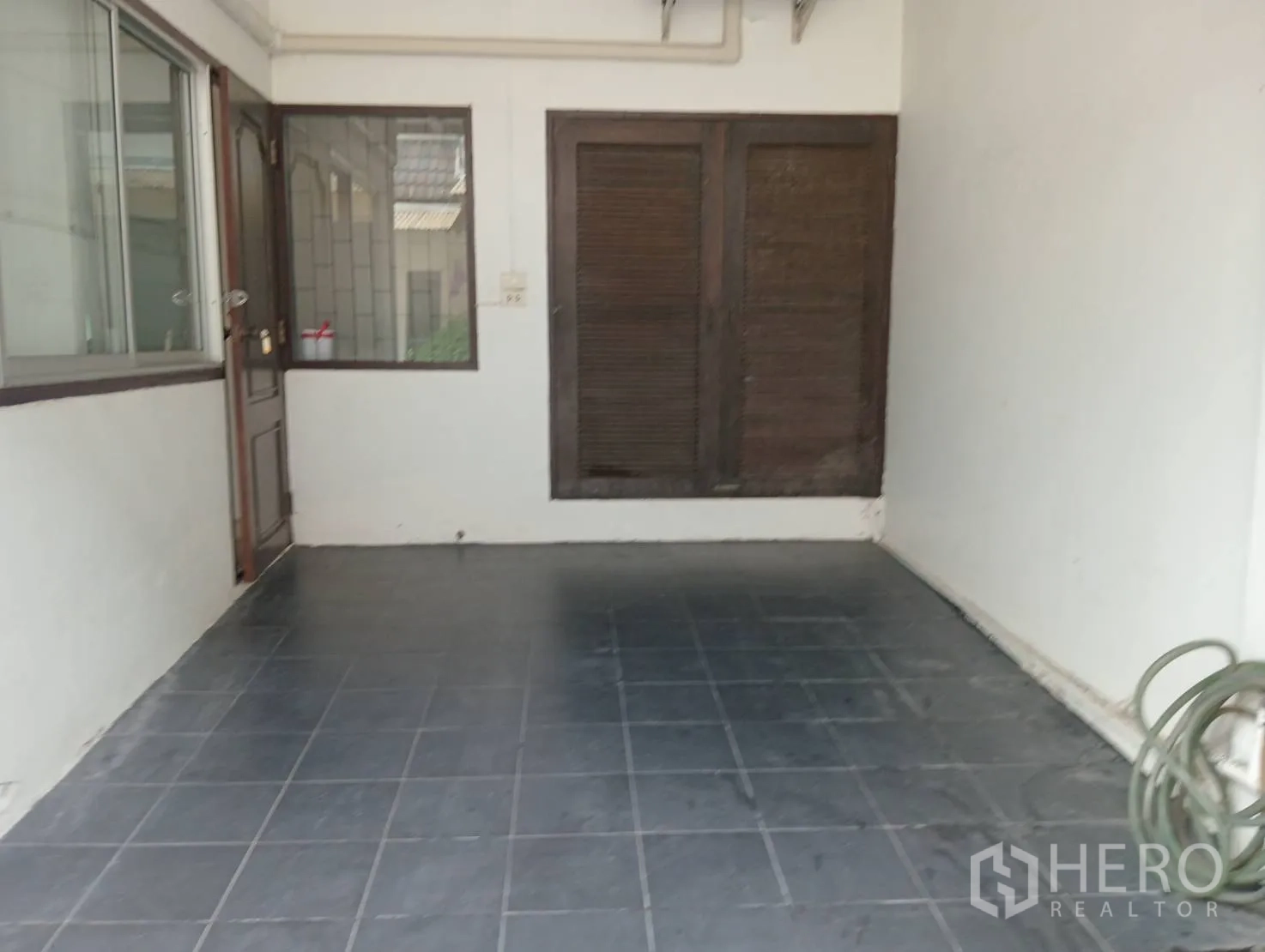 Home Office for rent in Khlong Toei, Bangkok - Covered parking bay with tiled floor and side entry door.