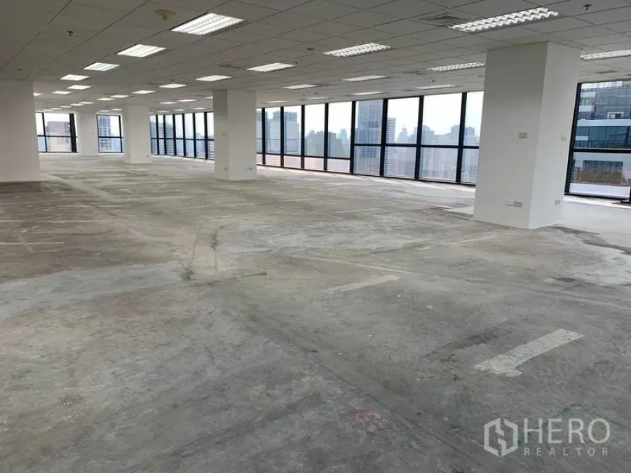 办公空间 出租在Ratchathewi, Bangkok - 宽敞的柱式办公区域，白色墙面与城市景观，等待装饰。